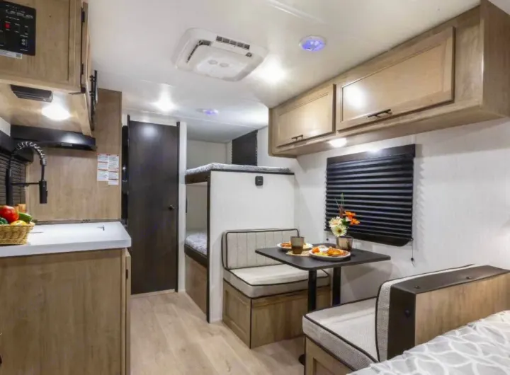 Cozy rv rental interior featuring a kitchenette with sink, dinette with food, and bunk beds for comfortable adventures.. Forest River Cherokee Wolf Pup 2023