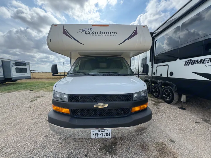 Front view of a white Coachmen Freelander rv rental in Texas, parked on gravel with other RVs under a cloudy sky.. Forest River Coachmen Freelander 2019