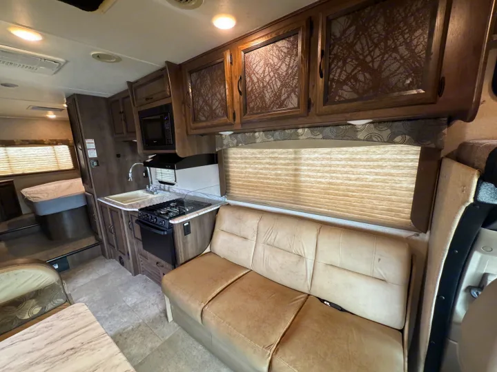 This rv rental offers a full kitchen, comfortable sofa, and dedicated bed area, perfect for road trip adventures.. Forest River Coachmen Freelander 2019