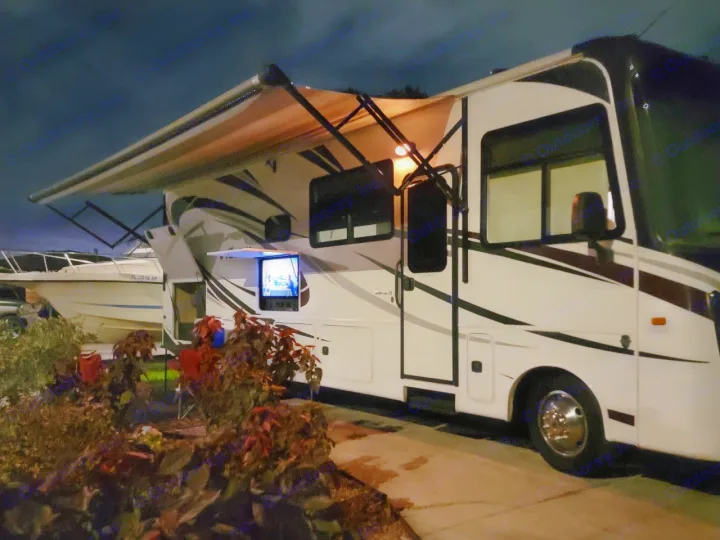 This RV rental offers nighttime entertainment with an outdoor TV, lighted awning, and waterfront views for camping.. Entegra Coach Vision 2019