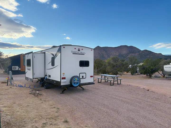 Enjoying the mountains in this Blue Compass RV rental, a North Trail Ultra Lite travel trailer, parked at a scenic campsite.. Heartland RVs North Trail 2021