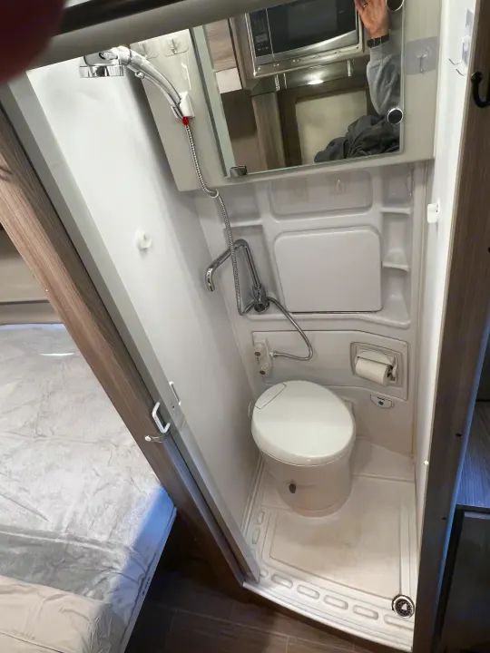 Efficient rv rental wet bath featuring a shower, toilet, and a mirrored cabinet reflecting the microwave. Ideal for travel.. Thor Sequence 20A 2021