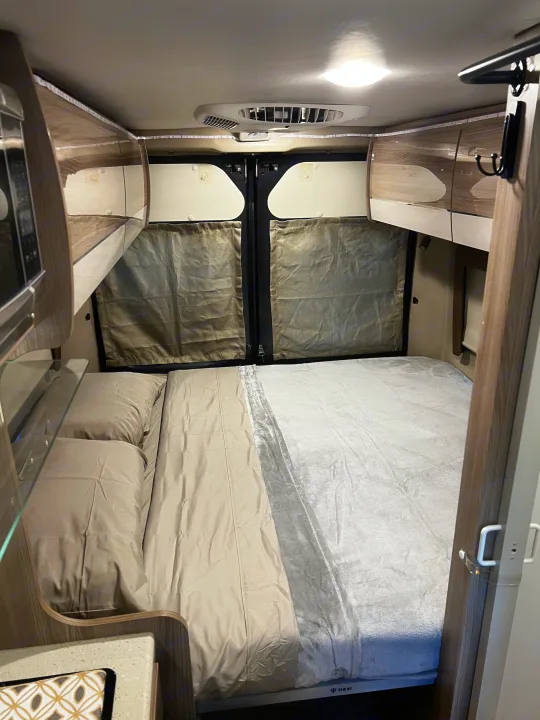 Cozy RV rental bedroom with a comfortable bed, overhead storage, and microwave, ready for your next adventure.. Thor Sequence 20A 2021