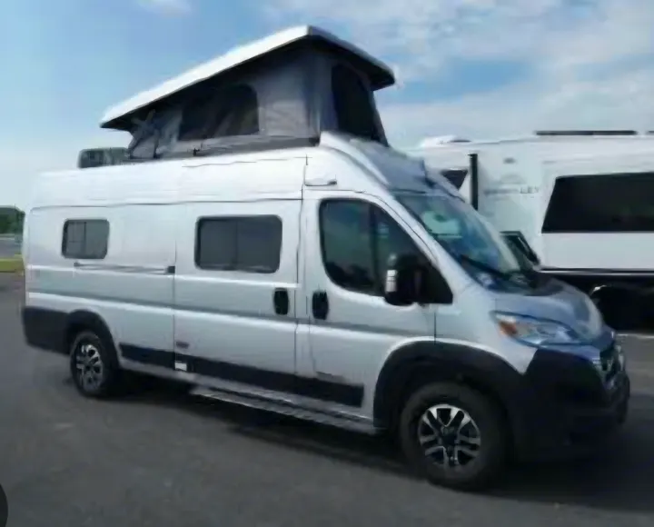 A silver camper van with its pop-top roof extended, hinting at extra sleeping space. Perfect for your next RV rental and camping adventure!. Winnebago Solis 2025