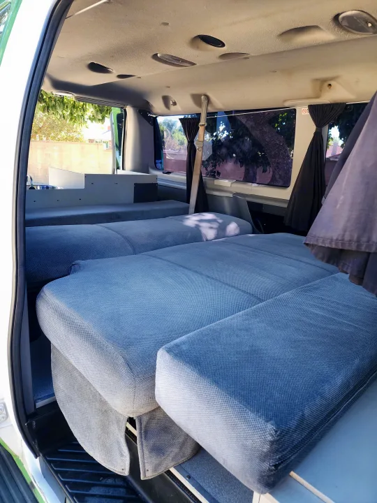 RV rental interior: a flexible camper van with modular blue beds, a compact sink, and overhead lighting for mobile living.. Escape Trailer Industries E150 XLT 2011