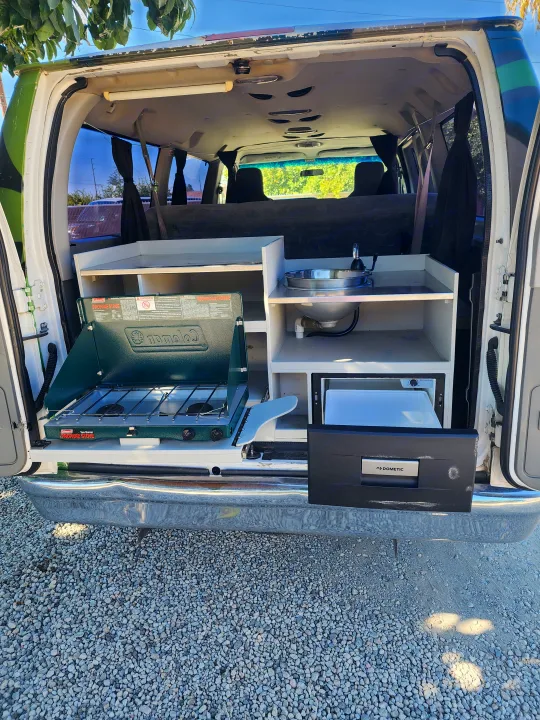 Explore with our RV rental camper van! Features a pull-out kitchen: Coleman stove, sink, and Dometic fridge.. Escape Trailer Industries E150 XLT 2011