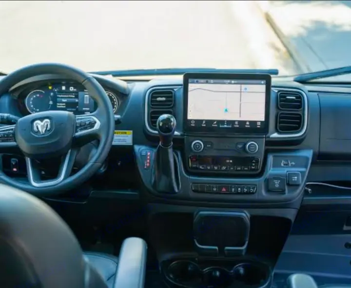 RV rental interior: Driver's perspective of the dashboard, RAM steering wheel, and navigation screen.. Winnebago Solis 2025