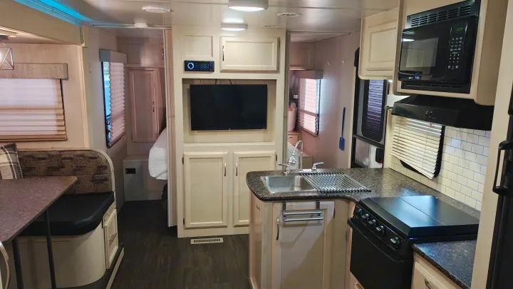 Inside a modern RV rental: a bright kitchen, comfortable dinette, and entertainment setup. Ready for your road trip!. Minnie Minnie Trailer 2019