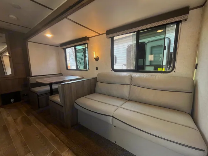This RV rental's interior boasts a dinette, comfy sofa, and ample windows, creating a welcoming travel living space.. Gulf Stream Kingsport 2023