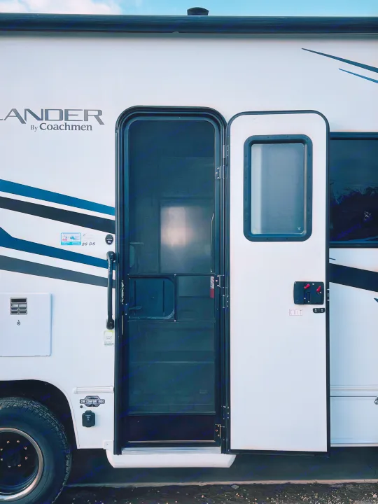 This RV rental shows a Coachmen Crosslander motorhome's open door with a screen, ready for your next adventure.. Forest River Coachmen Freelander Premier 2021