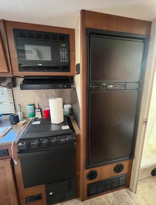 This RV rental features a full kitchen: microwave, range hood, stove, oven, and refrigerator in a compact setup.. Lance Manufacturing Lance Manufacturing Trailer 2016