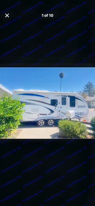 This RV rental is a white travel trailer with blue and brown graphics, parked on a sunny day.. Lance Manufacturing Lance Manufacturing Trailer 2016