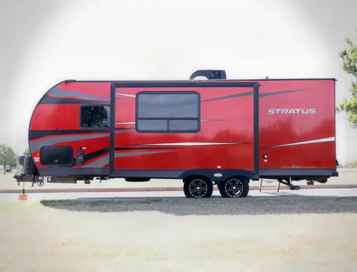 Side view of a bright red Stratus travel trailer RV rental with black and grey graphics, parked outdoors on a sunny day.. Venture Venture Trailer 2023