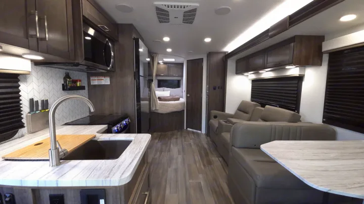 Modern RV rental interior with full kitchen, comfy living area, and private bedroom setup. Ideal for adventurous trips.. Entegra Coach Odyssey 25R 2026