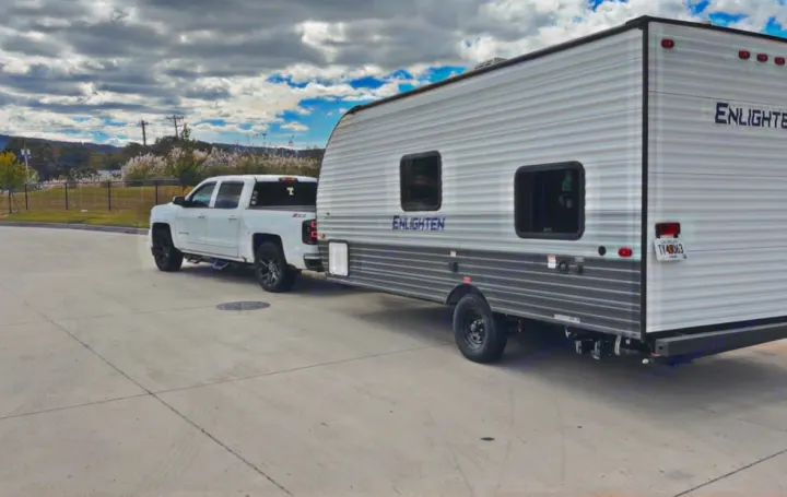 RV rental: A white pickup tows a travel trailer, ready for scenic camping & road trip adventures.. Gulf Stream Enlighten Super Lite 2025