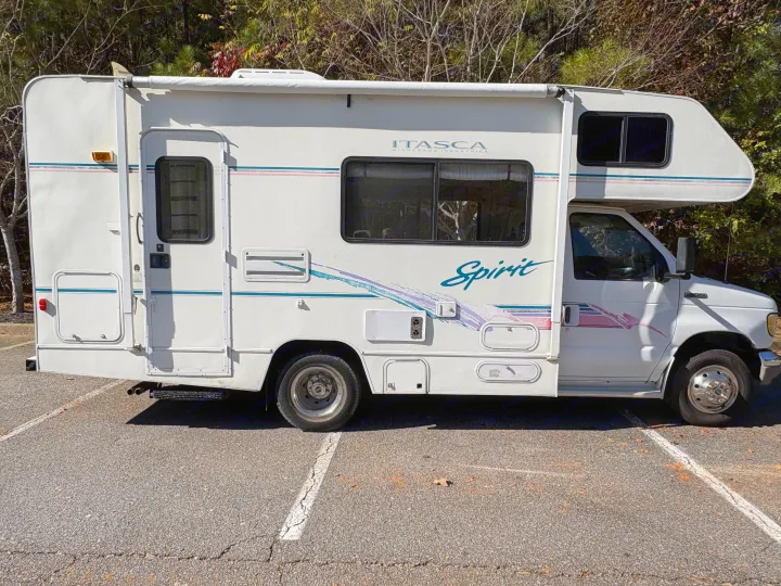 This white Itasca Spirit Class C rv rental is parked on asphalt, ready for a sunny outdoor adventure.. Itasca Spirit 1996