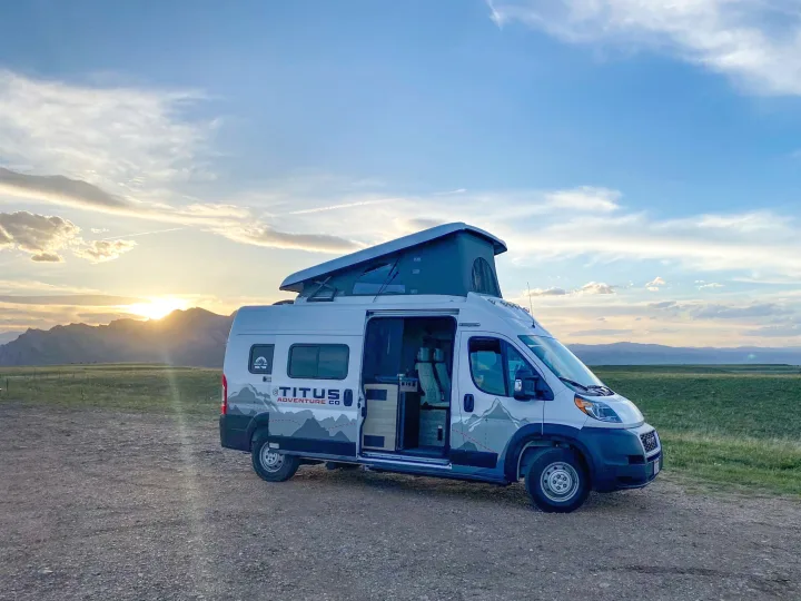 Adventure awaits! This Titus Adventure Co. rv rental camper van enjoys a stunning sunset over mountains & fields.. Winnebago Solis 2022