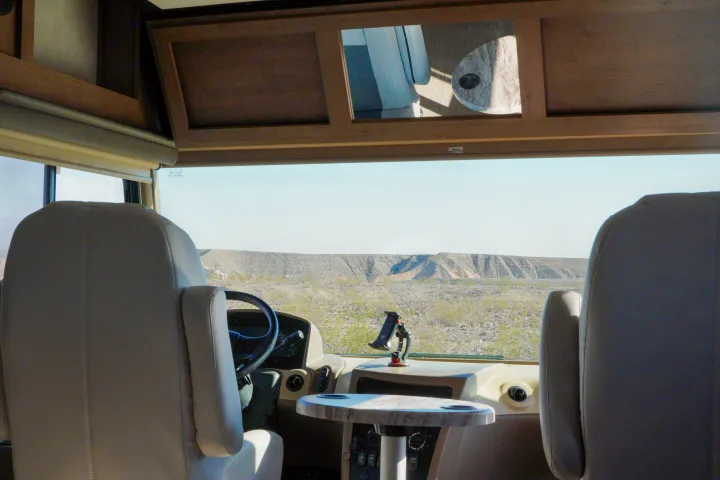 Enjoy the road trip! RV rental interior showcasing front seats, dashboard, and a scenic desert view from the windshield.. FR3 FR3 Motorhome 2019