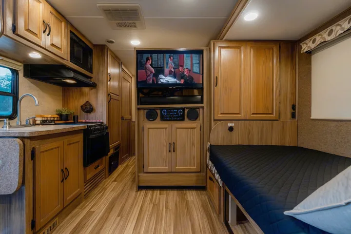 RV rental interior featuring a modern kitchen, entertainment center, and a cozy bedroom setup for comfortable travel.. Coachman Prism 2200 LE 2017