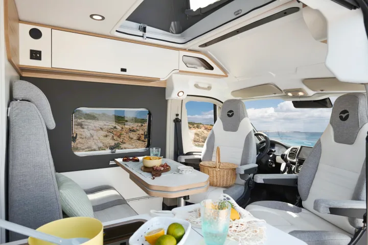 This spacious RV rental interior features a cozy dining area with a scenic ocean view, ideal for your next travel adventure.. PILOTE V600G 2026