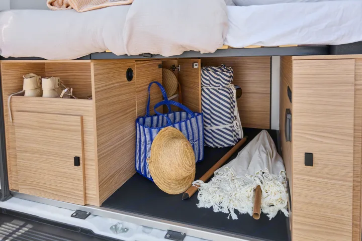 Smart rv rental storage: boots, beach tote, hat, and umbrella organized in under-bed compartments for travel.. PILOTE V600G 2026
