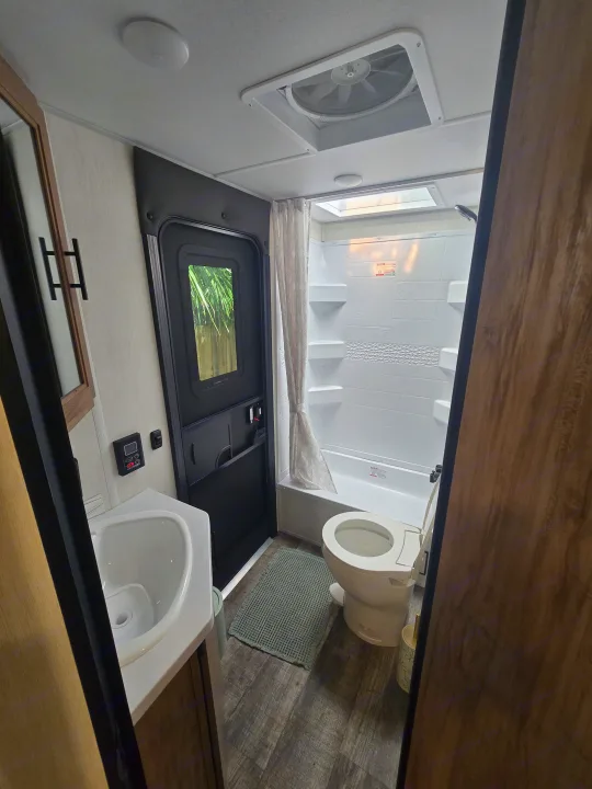 RV rental bathroom with shower, toilet, and sink, showing the compact yet functional space for your camper adventures.. Forest River Campsite Reserve 2025