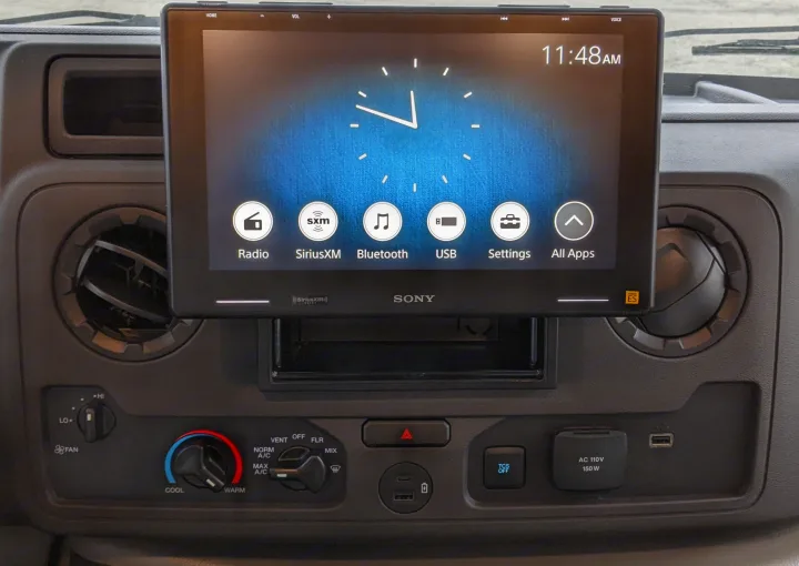 RV rental's dashboard features a Sony infotainment screen displaying 11:48 AM, climate controls, USB, and AC power outlets.. Forest River Sunseeker 2025