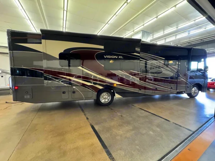 This luxurious Vision XL RV, with its striking dark and graphic design, is parked indoors and ready for your rv rental adventure.. Entegra Coach Vision XL 2021