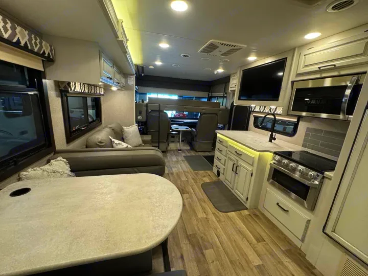 Inside a premium RV rental: full kitchen, bright living & dining areas. Your comfy home on the road awaits!. Entegra Coach Vision XL 2021