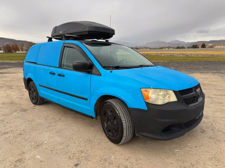 Bright blue textured van with Thule cargo box, a unique rv rental for adventures.. Ram C/V Tradesman 2014