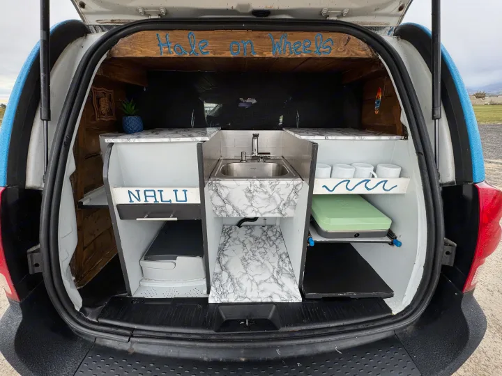This custom-built compact camper van's rear reveals a mini kitchen, storage, and portable toilet. Ideal for an rv rental road trip!. Ram C/V Tradesman 2014