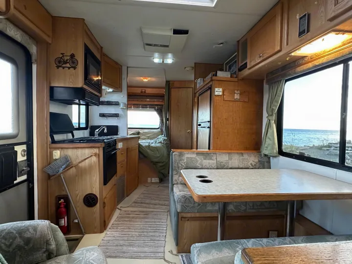 RV rental interior: Full kitchen, dinette, and cozy sleeping area with ocean views. Ready for your next camper adventure.. Ford E350 Travelmaster 1997