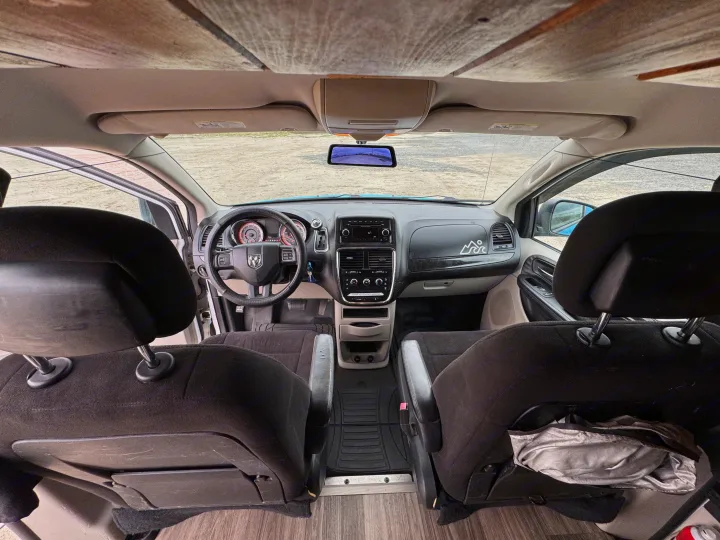 RV rental minivan interior. View from rear, showing front seats, dashboard, and custom wood ceiling/floor.. Ram C/V Tradesman 2014