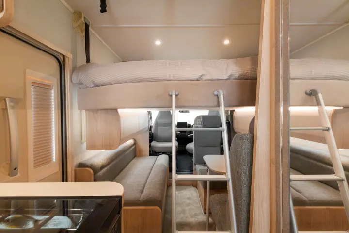Cozy RV rental interior: bunk bed with ladder, dinette, and kitchen. Light wood & gray tones create a modern, practical space for travel.. Elddis Whirlwind GT 196 2026