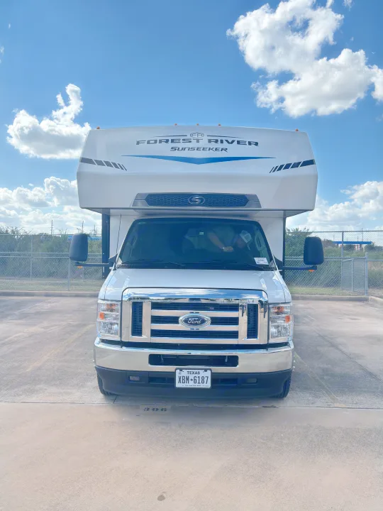 Front-facing shot of a white Forest River Sunseeker RV rental, built on a Ford chassis, parked under a clear blue sky.. Forest River Sunseeker Classic 2025