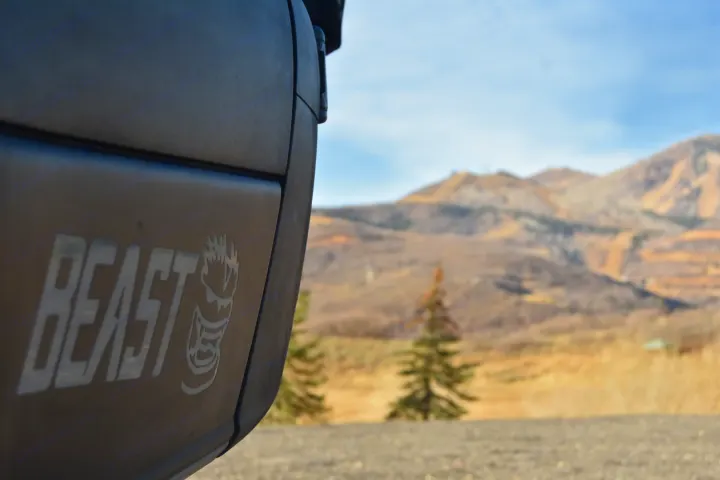 "BEAST" rv rental, prominent logo on dark surface, with blurred mountains & trees in scenic outdoor backdrop.. Storyteller Overland Storyteller Overland Class B 2023