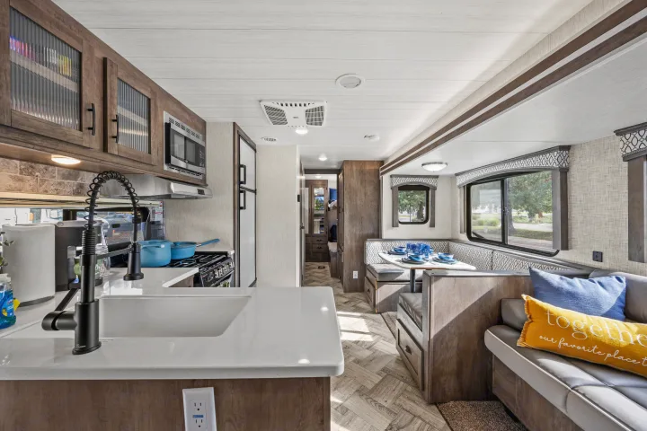 RV rental's inviting interior with full kitchen, dining booth, and comfy sofa for a relaxing journey.. Forest River EVO CSJT2990 2022