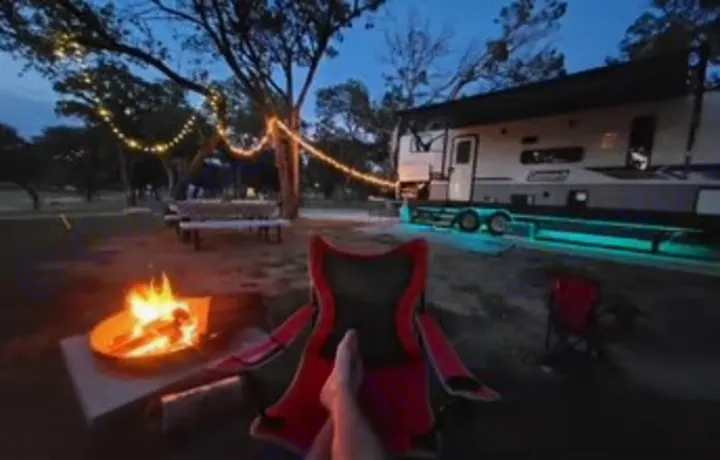 Enjoying a cozy campfire & string lights beside our RV rental travel trailer at dusk. Ultimate outdoor relaxation.. Dutchmen Coleman Lantern 2022