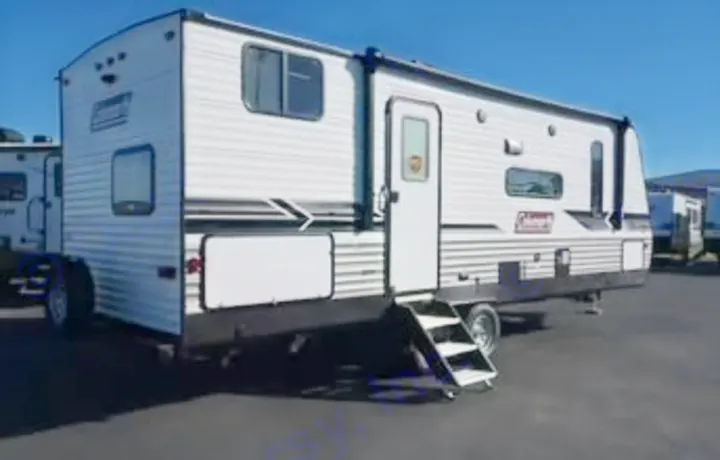 This white travel trailer RV rental, featuring a main door and steps, is ready for your next camping road trip adventure.. Dutchmen Coleman Lantern 2022