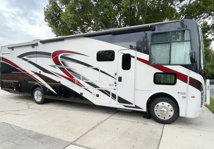 A large, modern Thor Windsport motorhome in white with black and red graphics, ideal for an RV rental or luxury road trip.. Thor Windsport 2023