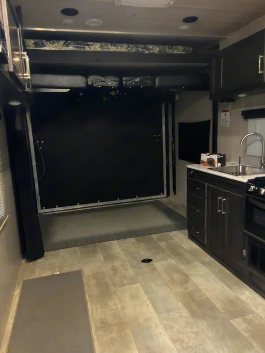 RV rental interior: modern kitchen, drop-down beds, and a spacious cargo area for gear in this toy hauler.. Genesis Supreme Rv Genesis Supreme 2022