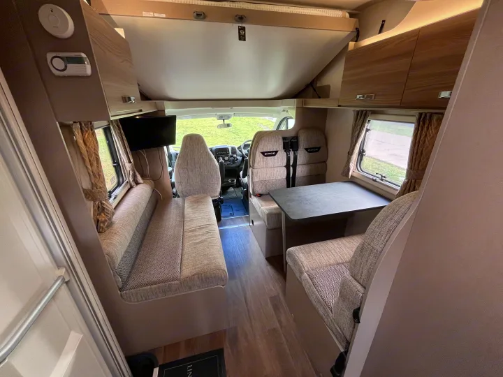 Experience comfort in this RV rental: spacious interior with dining area, overcab bed, and driver's cab.. Swift Edge 486 2024