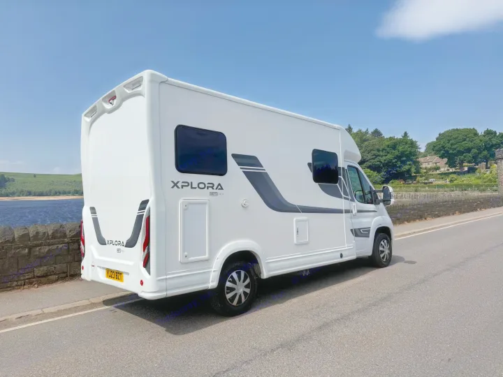 This white Xplora Mototrek RV rental is parked by a scenic lake, ready for a road trip adventure.. Moto-Trek Xplora FDB 2025