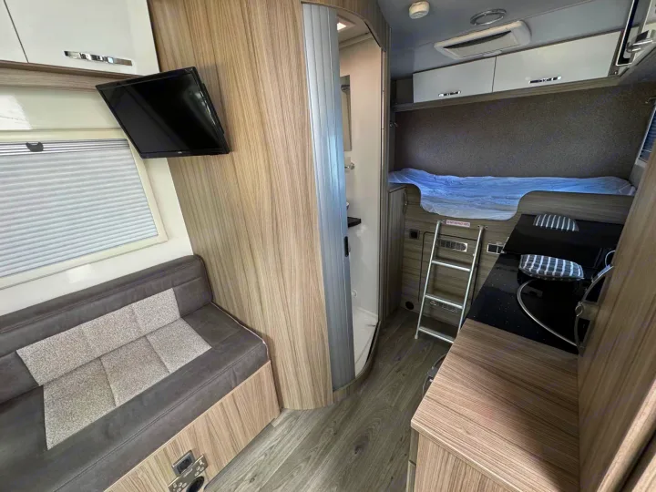 RV rental interior with cozy bunk beds, a compact kitchen, and a small bathroom, perfect for travel adventures.. Moto-Trek Xplora FDB 2025