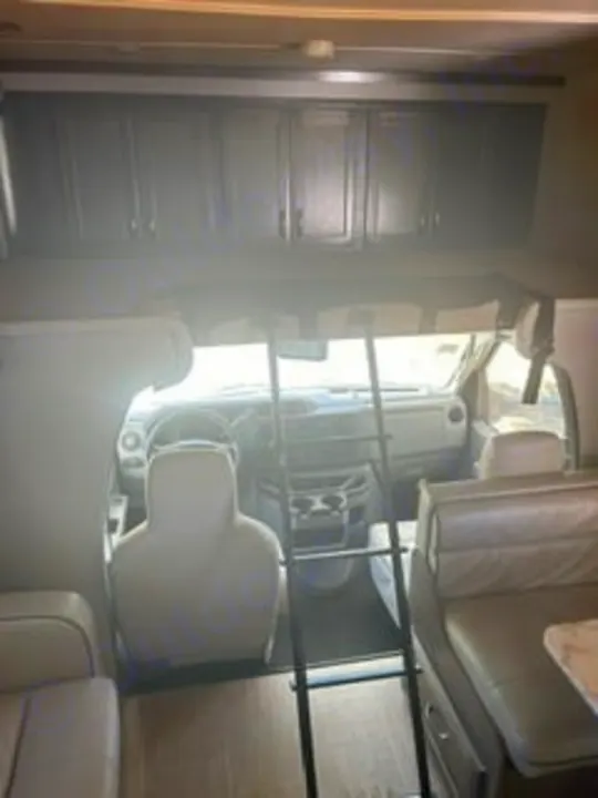 Spacious RV rental interior with driver's cockpit, over-cab bunk, and seating for comfortable travel adventures.. Gulf Stream Conquest 2022