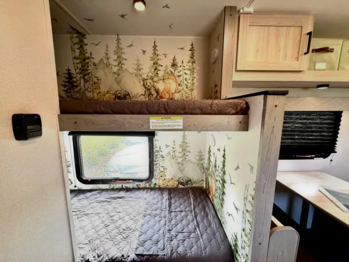 Cozy, family-friendly RV rental interior featuring themed bunk beds with a forest animal wallpaper, perfect for adventure.. Heartland RVs Mallard 2025