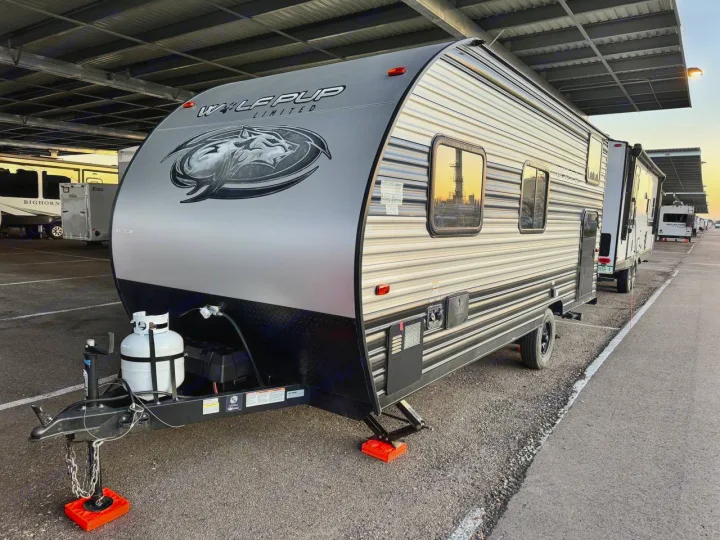 This Wolf Pup travel trailer, an ideal RV rental, is parked under covered storage, ready for camping adventures.. Forest River Cherokee Wolf Pup 2021