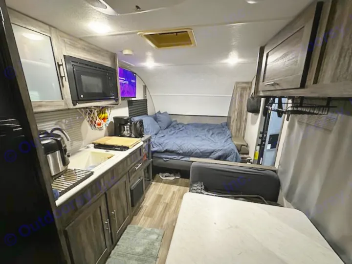 This rv rental interior features a compact kitchen, comfy bed, and dining area, ready for adventure.. Forest River Salem FSX PLATINUM 2020