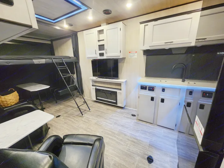 Spacious rv rental interior featuring bunk beds, kitchenette, TV, electric fireplace, and comfortable seating.. Genesis Supreme Rv Genesis Supreme 2026