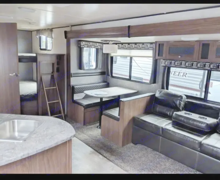 Spacious RV rental interior with living area, dinette, kitchen, and bunk beds. Perfect for family adventures.. Pioneer Bunkhouse 2019